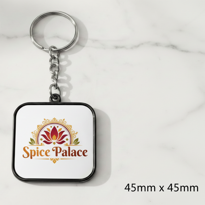 Keychain with 'Spice Palace' logo on a white marble background
